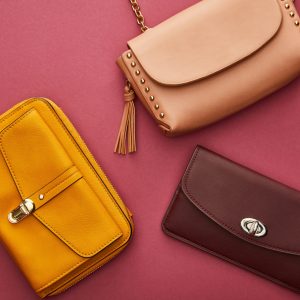 top view of leather and stylish bags isolated on crimson